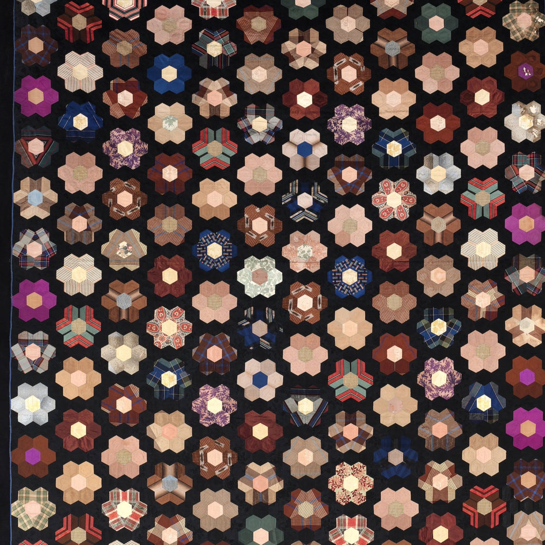 This puzzle features a quilt with a pieced flower pattern; colorful flowers on a black background. Available in Moderate and Difficult Levels.